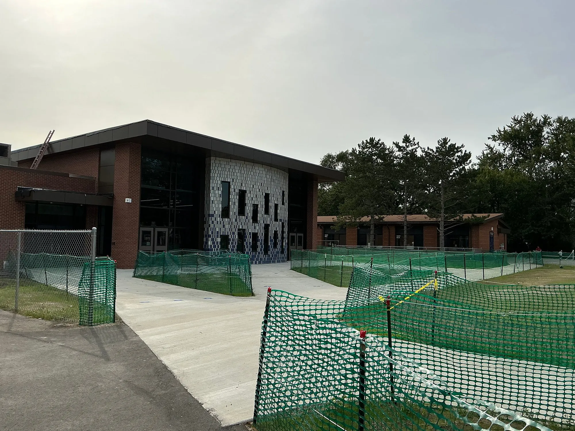 New brick and patterned-panel addition at Rogers Elementary behind construction fencing