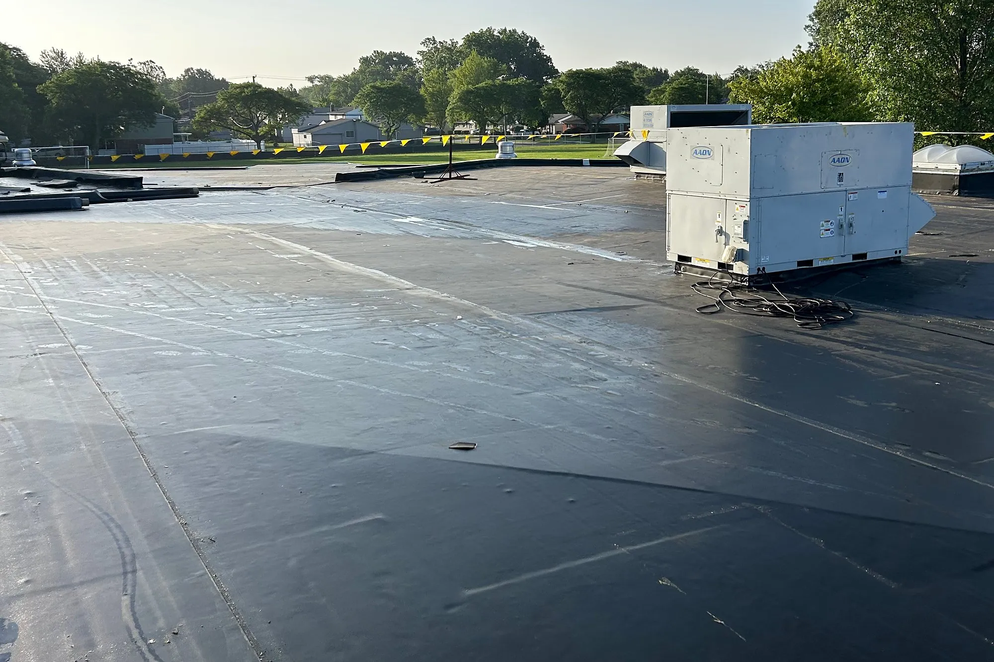 New black roof membrane around a rooftop mechanical unit