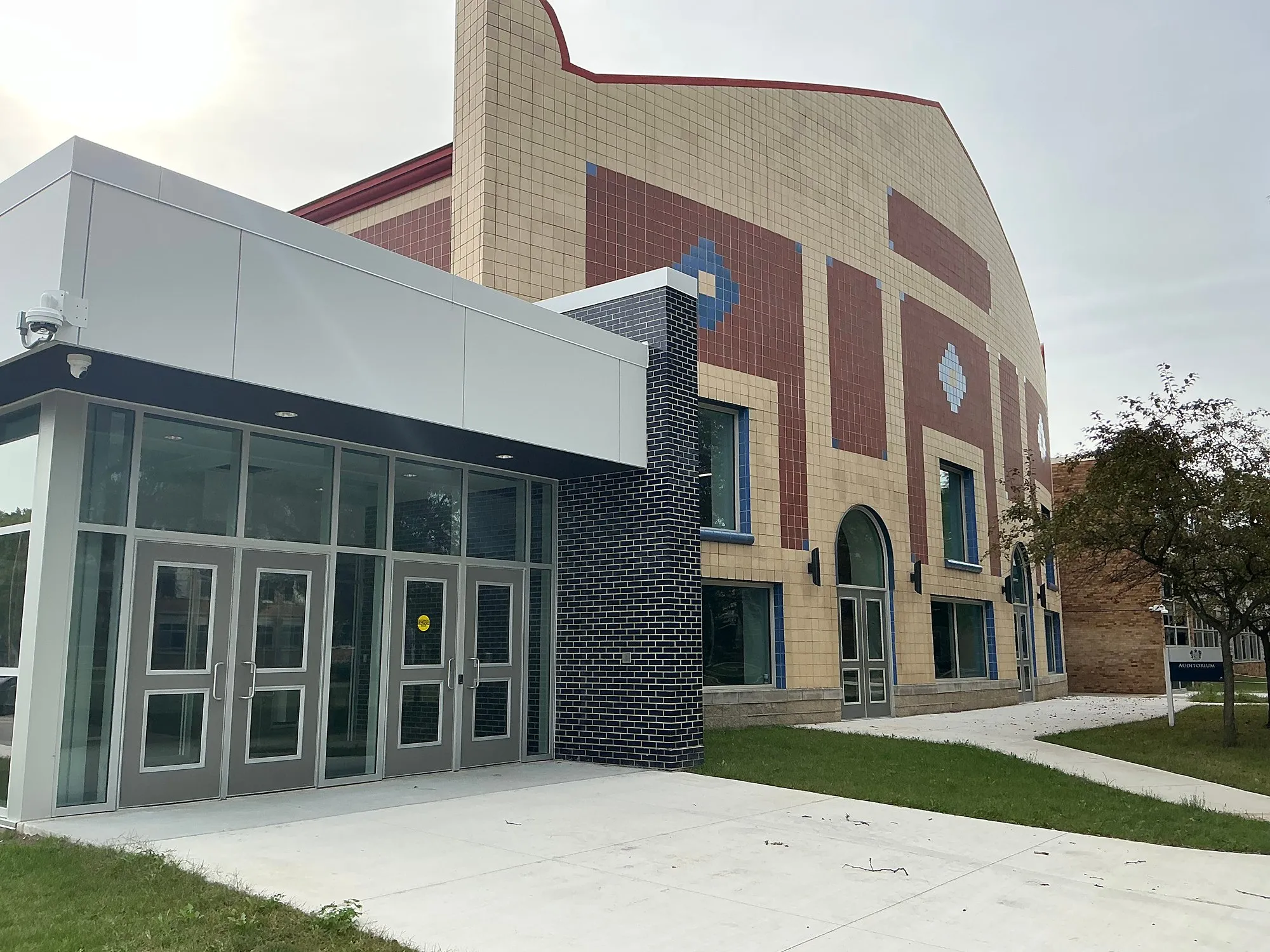 New glass entrance at Berkley High School in front of the brick theater