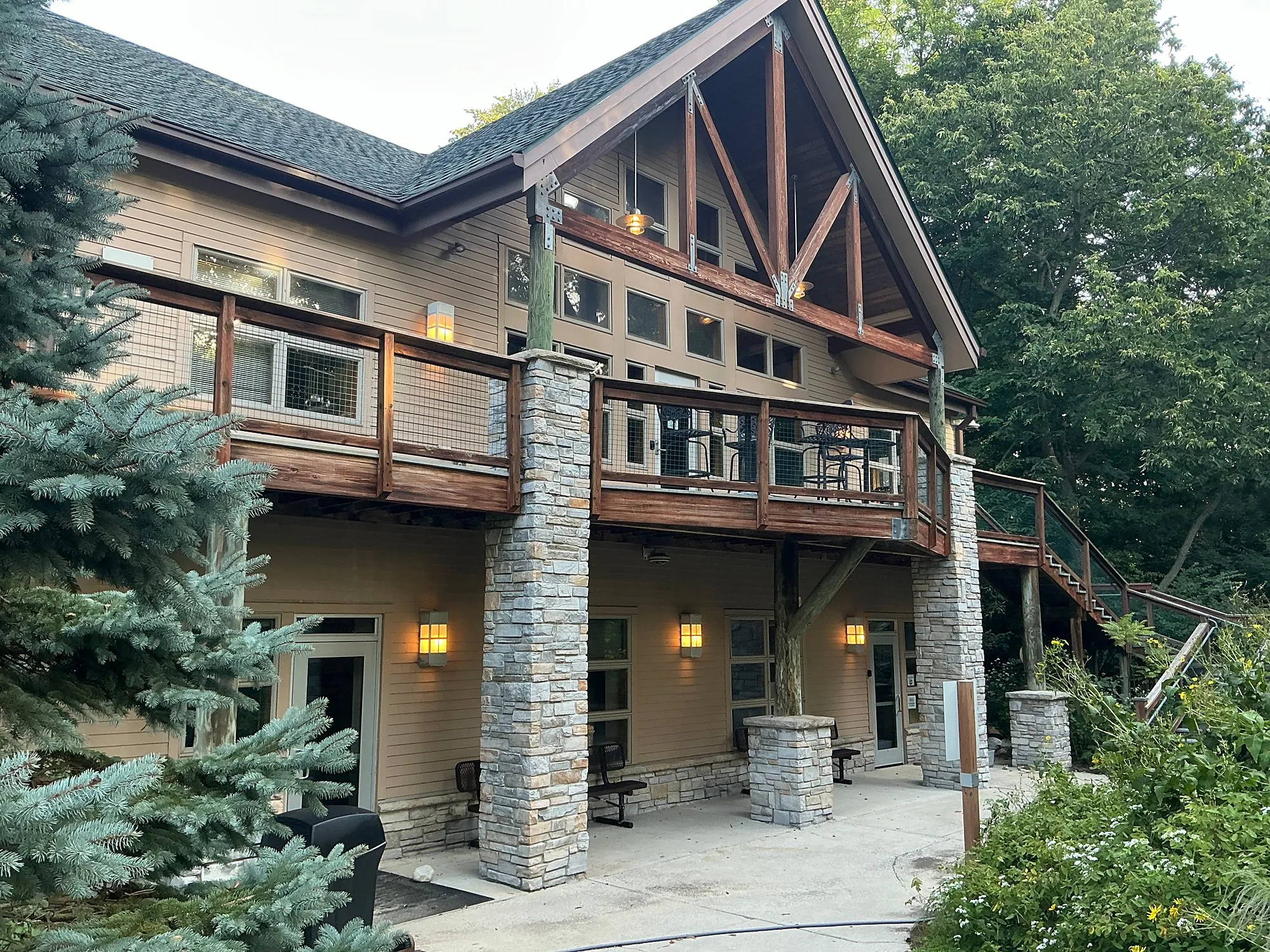 Two-story wing of the E.L. Johnson Nature Center with a wraparound deck and stone columns