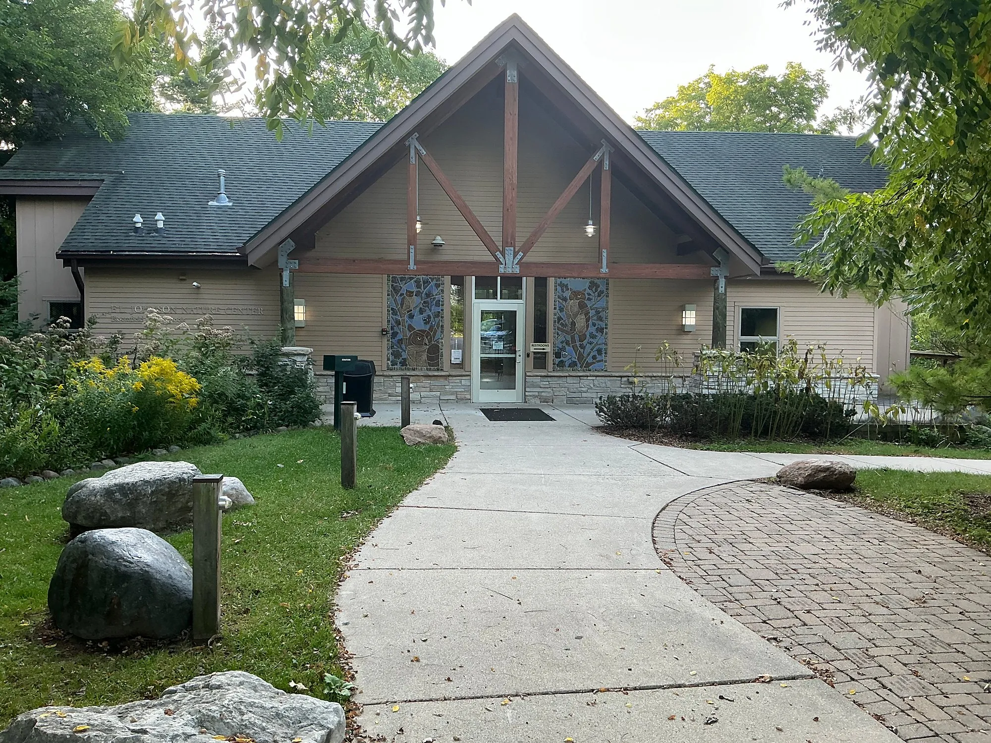 E.L. Johnson Nature Center entrance with timber gable, stone walk and boulders